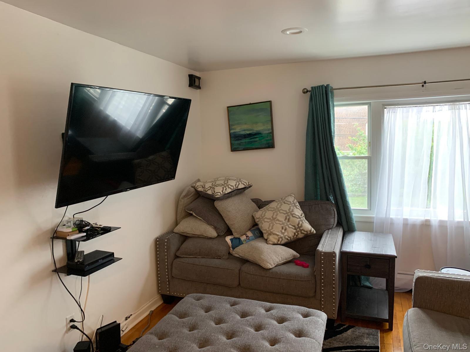 217-05 104th Avenue Queens, NY 11429 - Photo 10 of 43 a living room with furniture and a flat screen tv