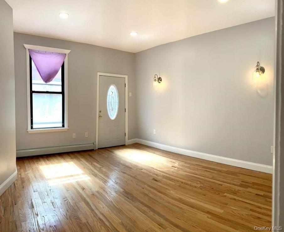 2301 Bathgate Avenue Bronx, NY 10458 - Photo 12 of 25 an empty room with wooden floor and windows