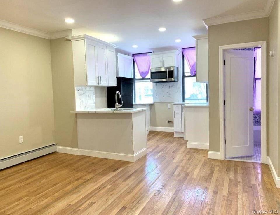2301 Bathgate Avenue Bronx, NY 10458 - Photo 18 of 25 a kitchen with granite countertop a stove top oven a sink and cabinets