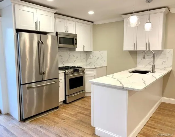 a kitchen with appliances a sink and a refrigerator