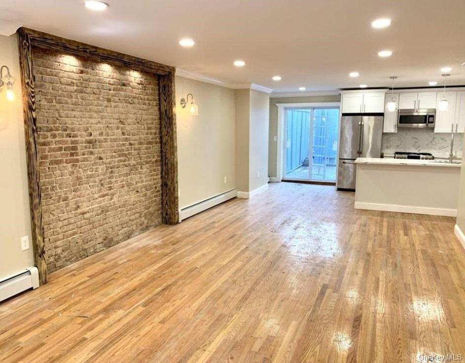2301 Bathgate Avenue Bronx, NY 10458 - Photo 5 of 25 a view of large kitchen with kitchen island a sink wooden floor and a refrigerator