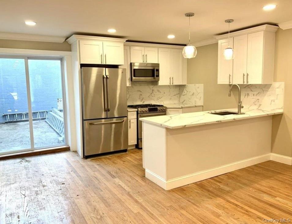 2301 Bathgate Avenue Bronx, NY 10458 - Photo 6 of 25 a kitchen with stainless steel appliances granite countertop a refrigerator a sink and a stove
