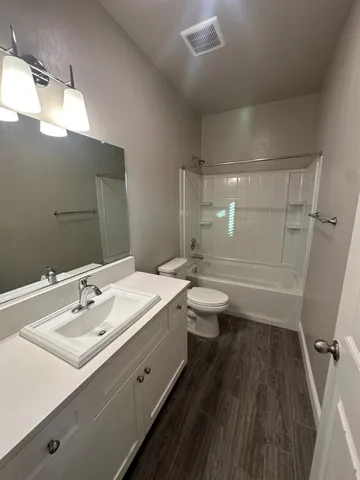 a bathroom with a double vanity sink toilet and shower