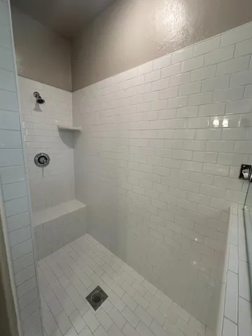 a white toilet sitting next to a shower