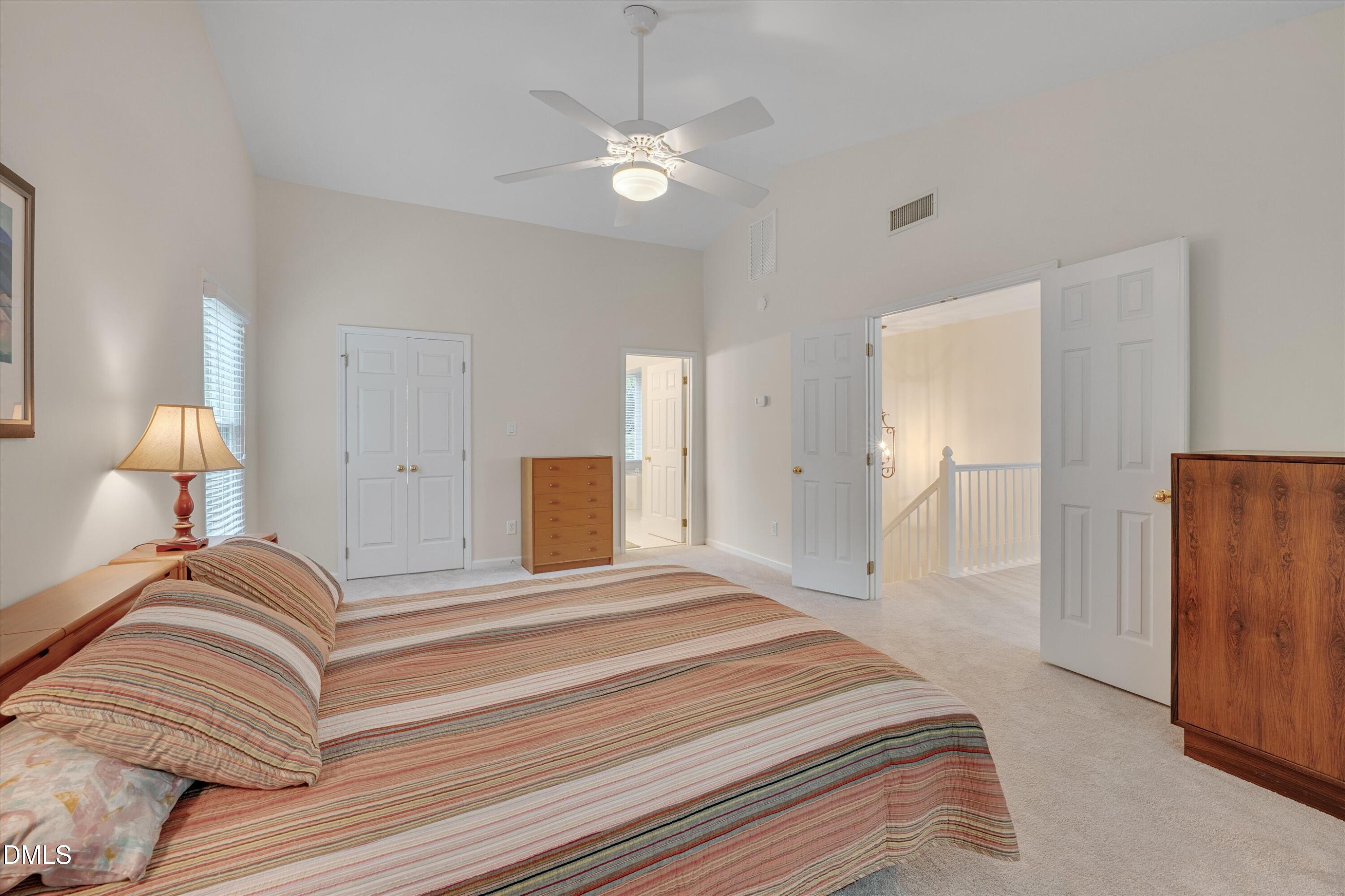 205 Cates Farm Road Chapel Hill, NC 27516 - Photo 31 of 56 a bedroom with a large bed and a chandelier