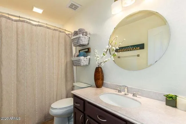 a bathroom with a granite countertop sink a toilet and a mirror
