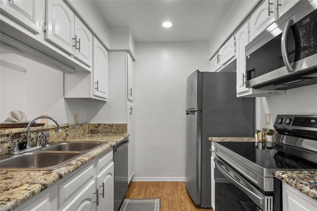 5100 Verde Valley Lane, Unit 245 Dallas, TX 75254 - Photo 11 of 24 a kitchen with stainless steel appliances granite countertop a sink stove and refrigerator