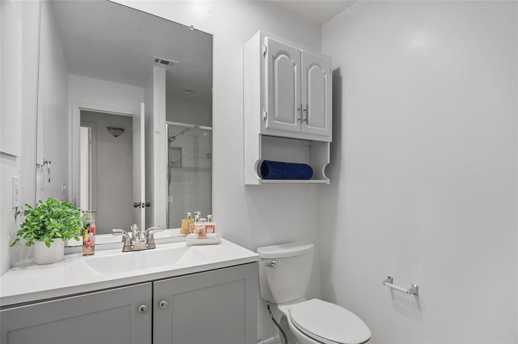 5100 Verde Valley Lane, Unit 245 Dallas, TX 75254 - Photo 19 of 24 a bathroom with a toilet sink and mirror