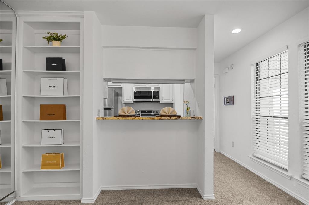 5100 Verde Valley Lane, Unit 245 Dallas, TX 75254 - Photo 9 of 24 a living room with stainless steel appliances furniture a rug and a window