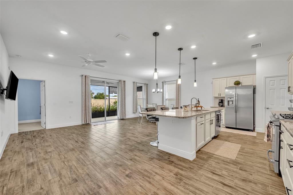 134 Silver Maple Road Groveland, FL 34736 - Photo 11 of 73 a kitchen with stainless steel appliances kitchen island wooden cabinets and granite counter tops