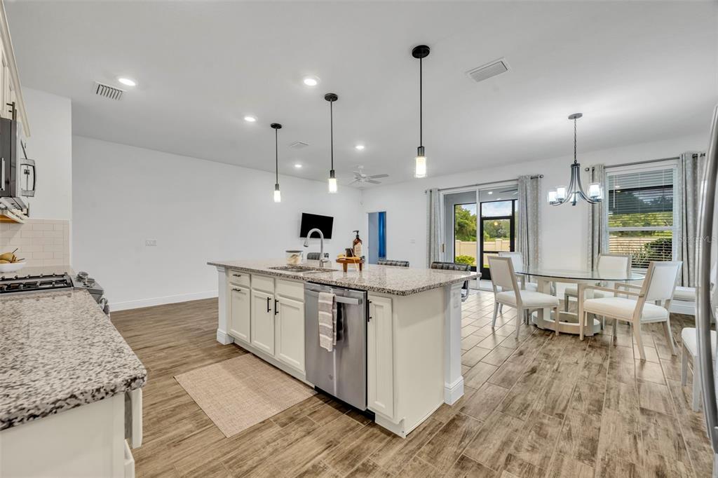 134 Silver Maple Road Groveland, FL 34736 - Photo 23 of 73 a kitchen with stainless steel appliances granite countertop a sink stove and wooden floor
