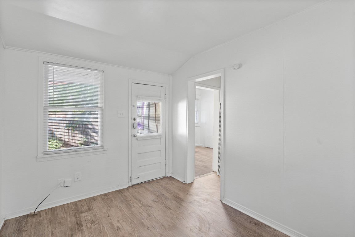 3404 Grooms Street, Unit B Austin, TX 78705 - Photo 2 of 11 Unfurnished room featuring wood finished floors, lofted ceiling, baseboards, and a smoke detector