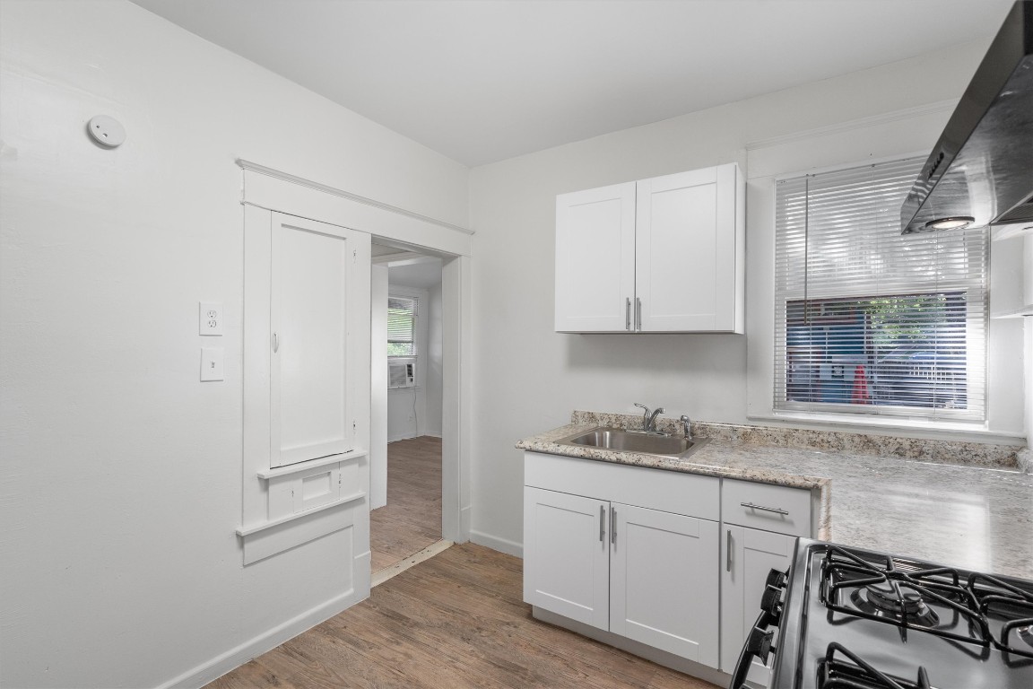 3404 Grooms Street, Unit B Austin, TX 78705 - Photo 5 of 11 Kitchen with a sink, range with gas stovetop, light wood-style flooring, light countertops, and baseboards