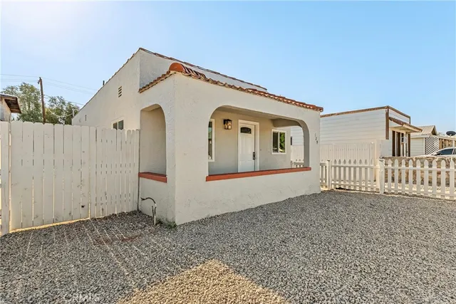 a view of a house with a small yard and wooden fence
