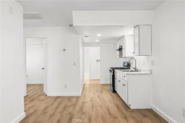 a view of a kitchen with sink and dishwasher with wooden floor