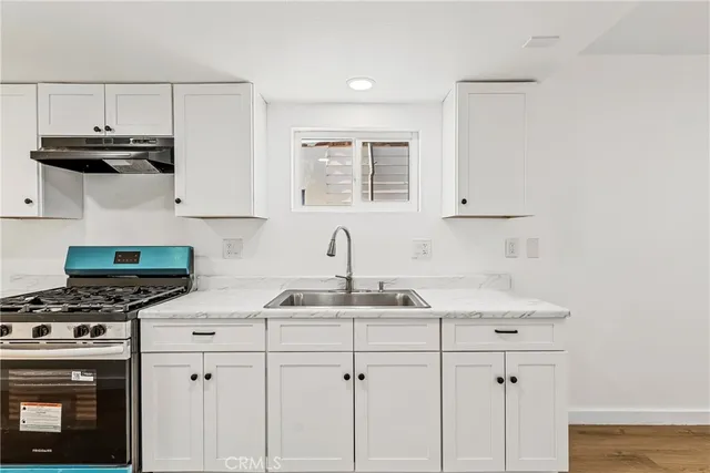 a kitchen with stainless steel appliances a sink stove and cabinets