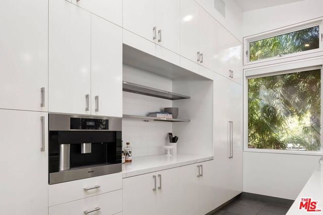 a view of kitchen with cabinets and window