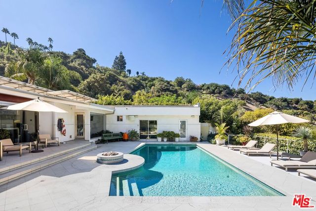 a swimming pool with outdoor seating and a potted plant