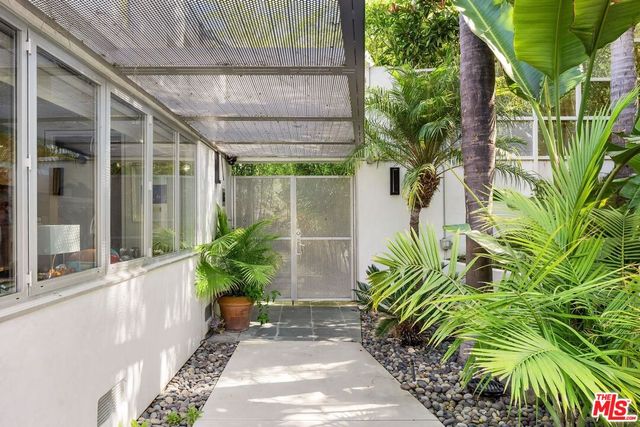 a view of house with wooden door and potted plant