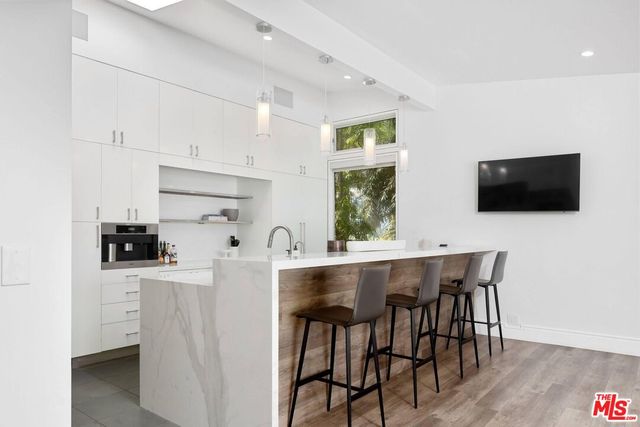 a kitchen with stainless steel appliances a table chairs microwave and sink
