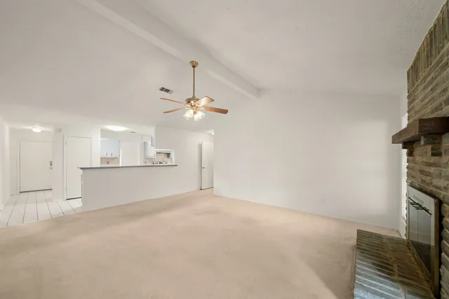 an empty room with a fireplace and fan