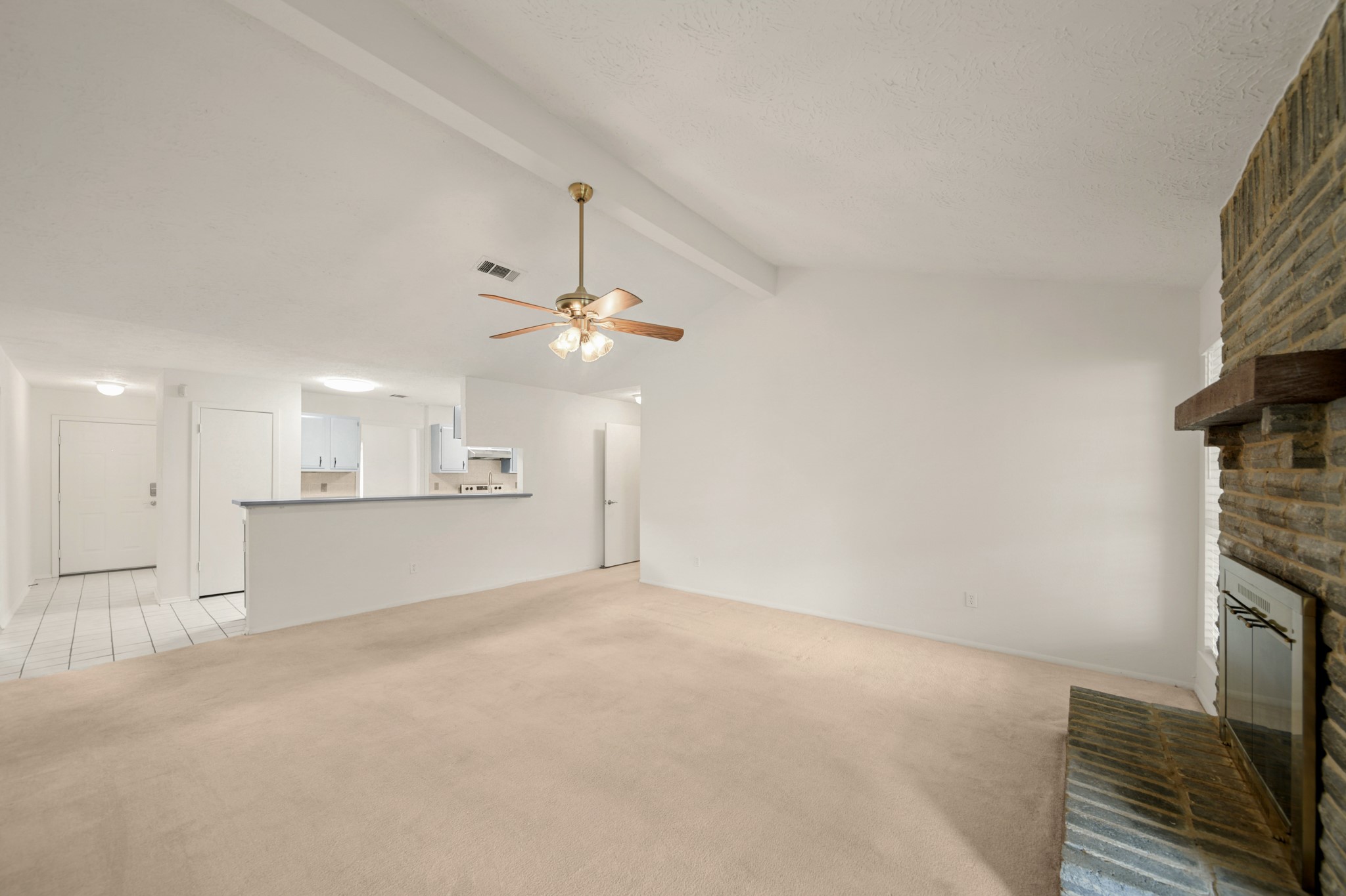 9903 Robin Street La Porte, TX 77571 - Photo 11 of 25 an empty room with a fireplace and fan
