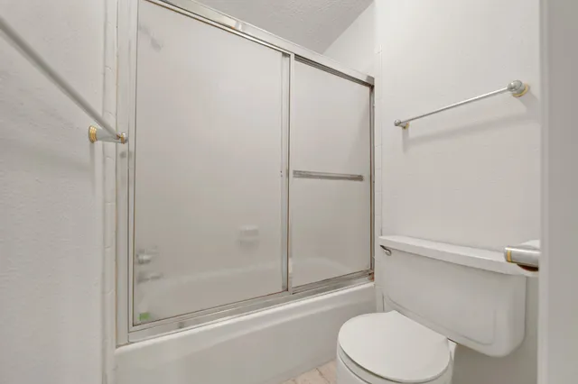 a white toilet next to a bathroom