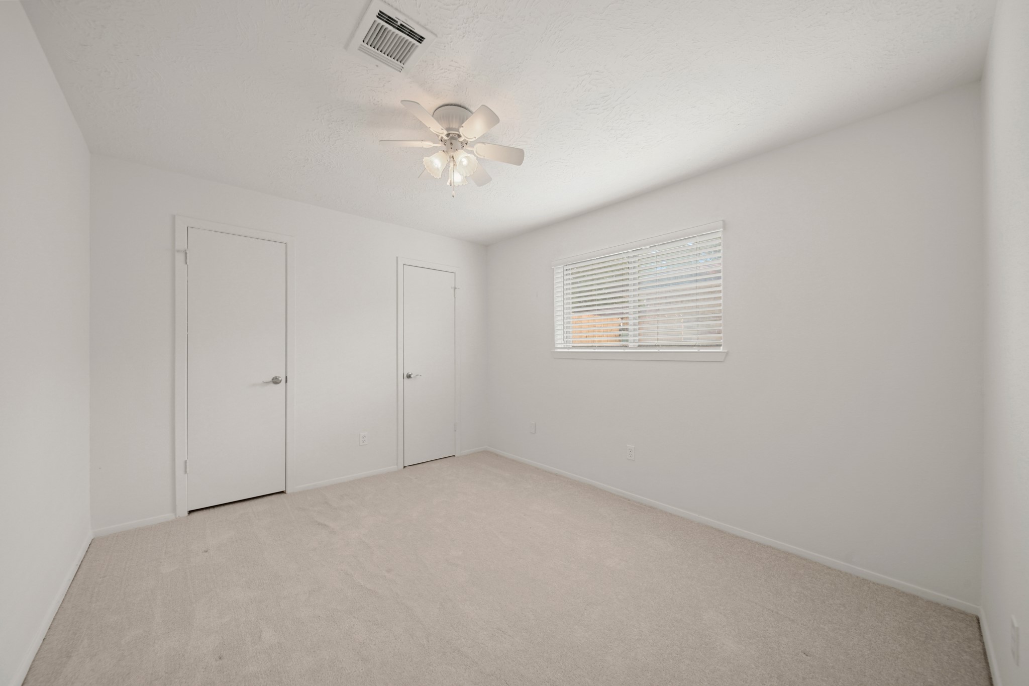 9903 Robin Street La Porte, TX 77571 - Photo 19 of 25 en empty room with windows and chandelier fan