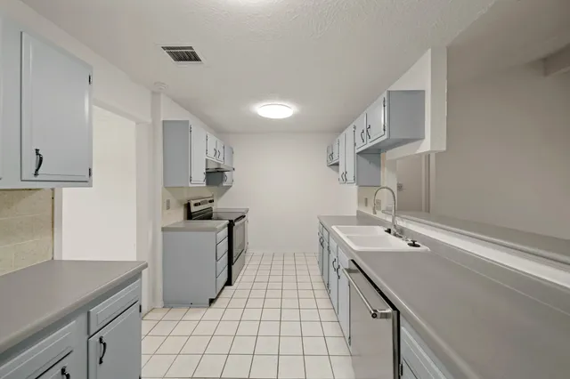a kitchen with a sink stainless steel appliances and cabinets