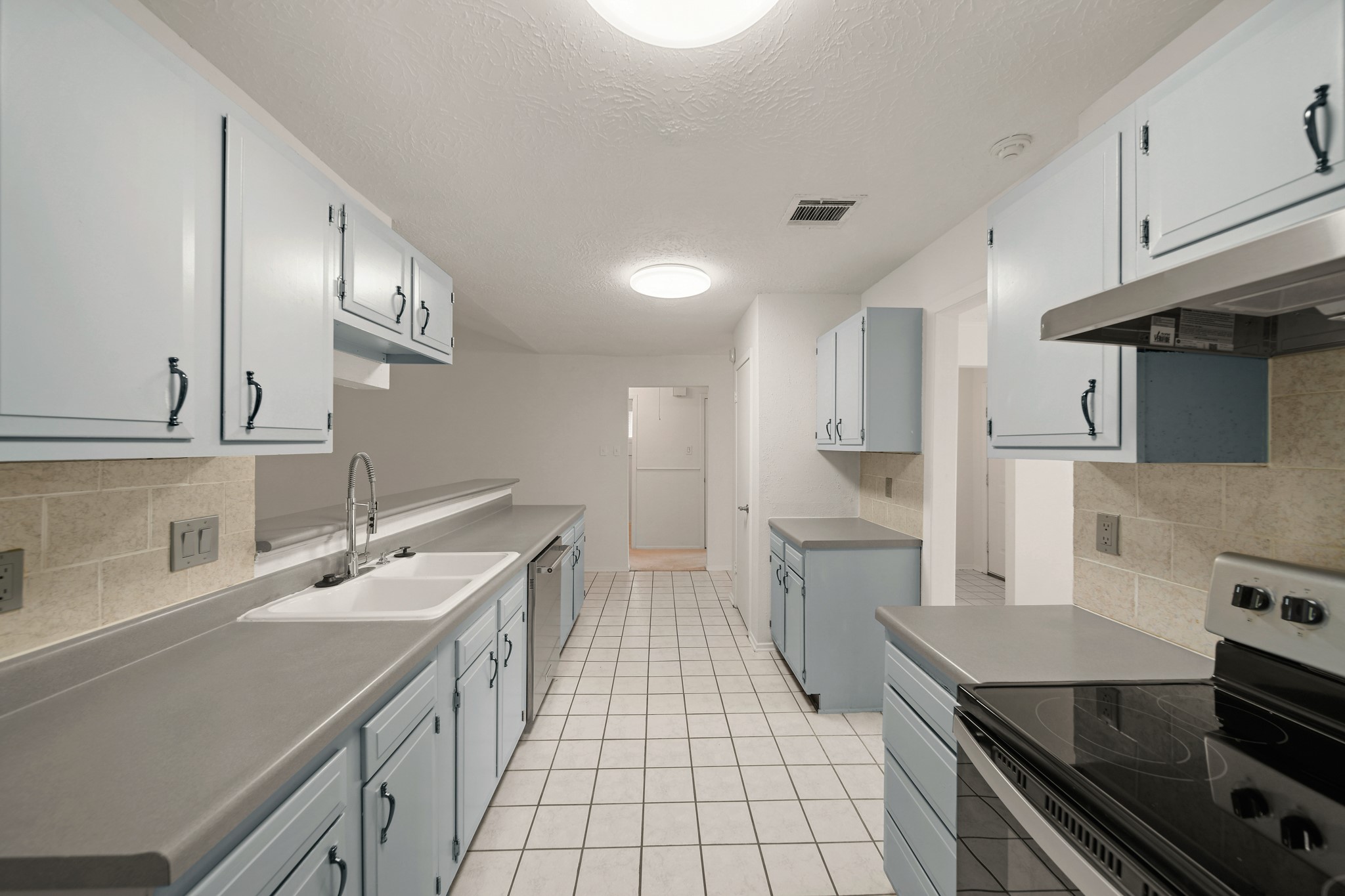 9903 Robin Street La Porte, TX 77571 - Photo 6 of 25 a kitchen with a sink stainless steel appliances and white cabinets