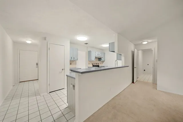 a large white kitchen with a sink and cabinets