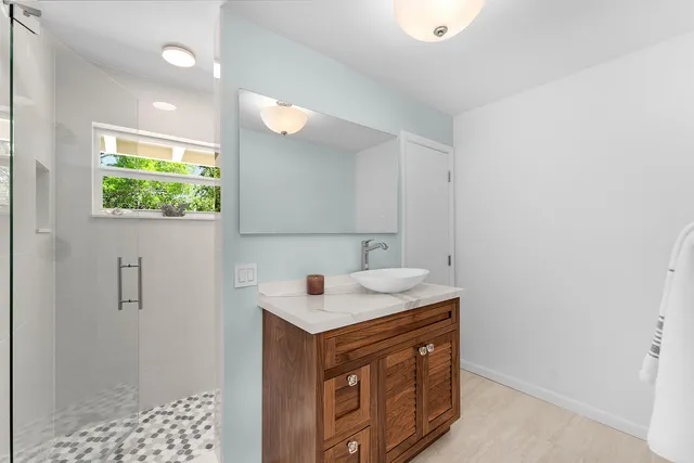 a bathroom with a granite countertop sink a shower and a mirror