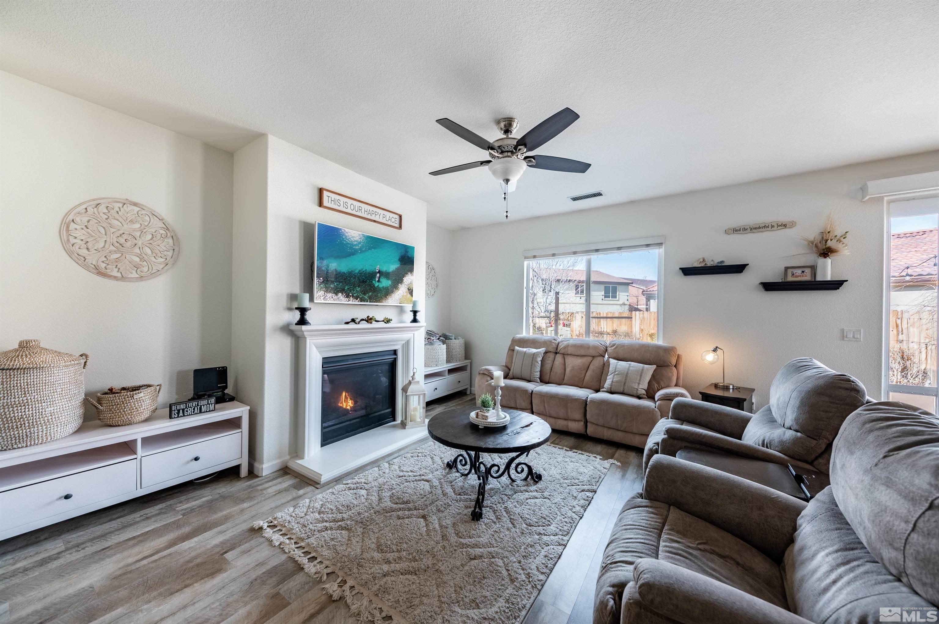 2045 Tawleed Road Reno, NV 89521 - Photo 9 of 33 a living room with furniture a fireplace and a flat screen tv