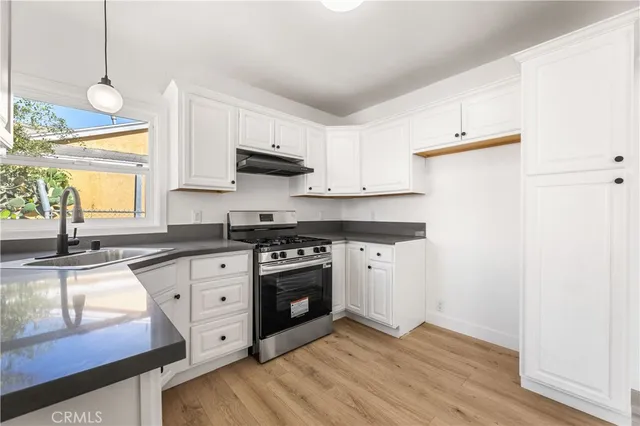 a kitchen with stainless steel appliances granite countertop a sink a stove and a refrigerator