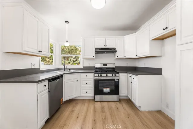 a kitchen with stainless steel appliances granite countertop a stove a sink and a refrigerator