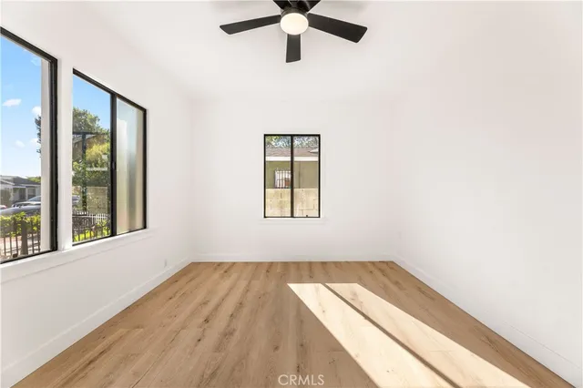 an empty room with a window and a ceiling fan