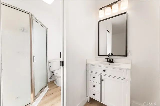a bathroom with a double vanity sink a toilet and a mirror