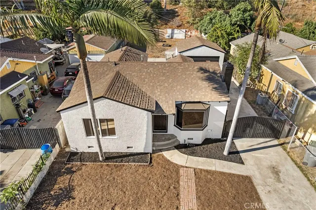 a view of a white house with palm trees