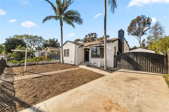 a front view of a house with palm trees
