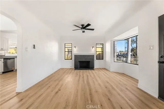 an empty room with windows and fireplace