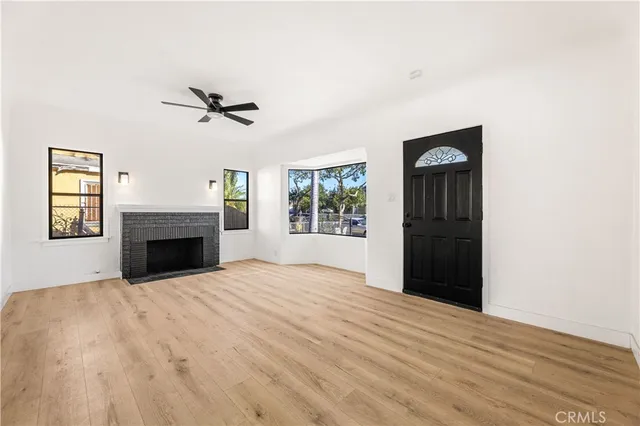 a view of an empty room with a fireplace and a window