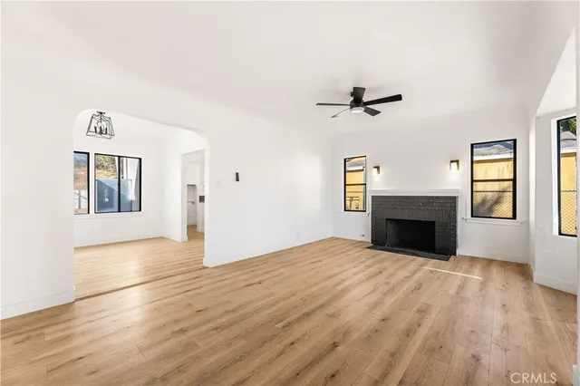 a view of an empty room with window and wooden floor