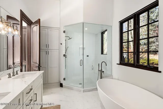 a bathroom with a tub sink and mirror