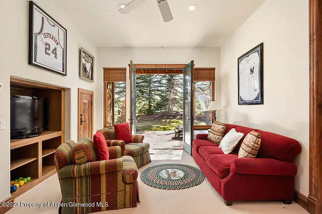 a living room with furniture ceiling fan and a large window