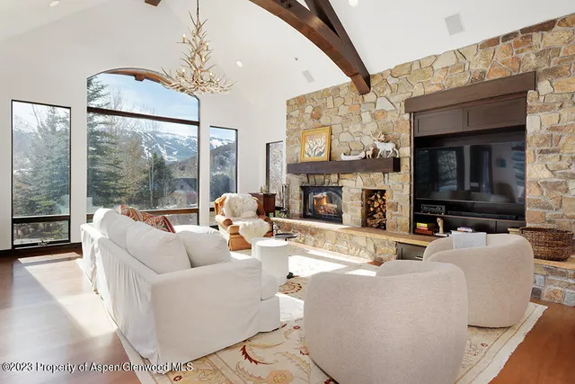 a living room with furniture a large window and a fireplace