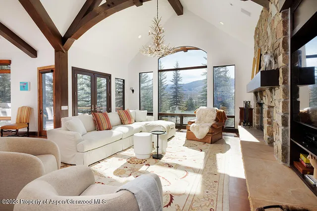 a living room with furniture fireplace and a large window