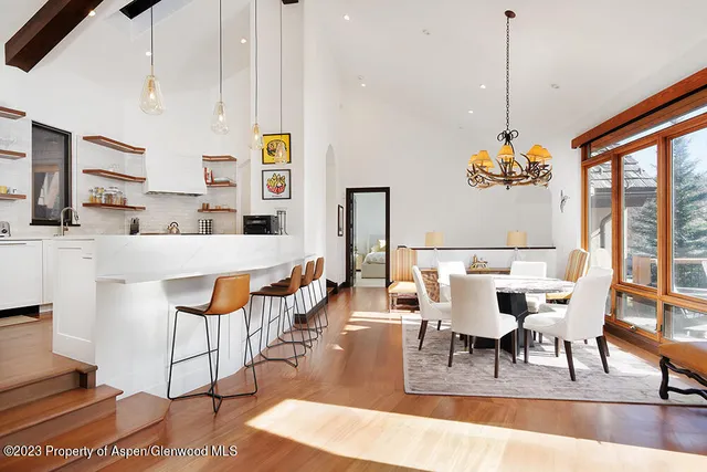 a dining room with furniture a chandelier and wooden floor
