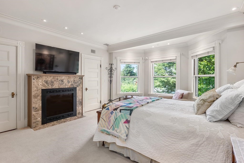 28 Monadnock Road Newton, MA 02467 - Photo 15 of 23 a bed sitting in a spacious bedroom next to a window and a fireplace