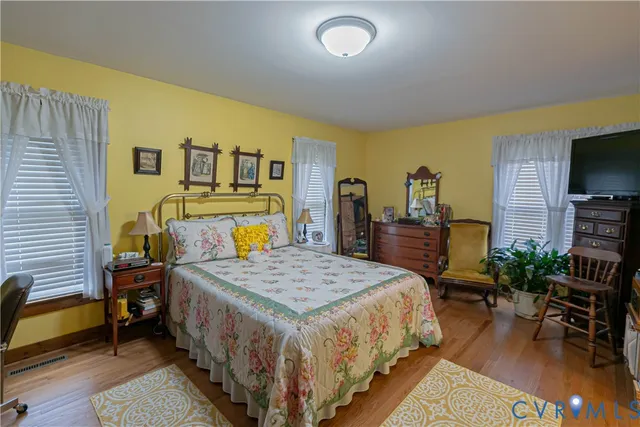 a bedroom with a bed a table and a flat screen tv