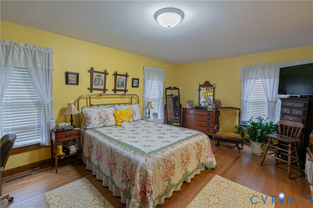 19321 River Road Chesterfield, VA 23838 - Photo 38 of 50 a bedroom with a bed a table and a flat screen tv